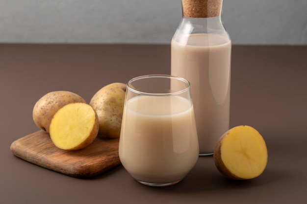 Concetto di latte alternativo Vaso con latte di patata su sfondo marrone