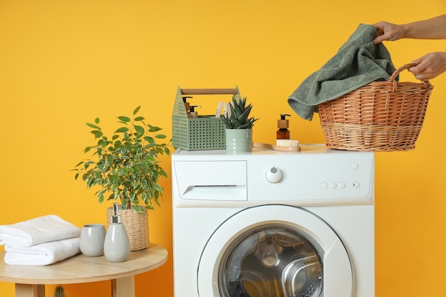 Concetto di lavori domestici con lavatrice su sfondo giallo