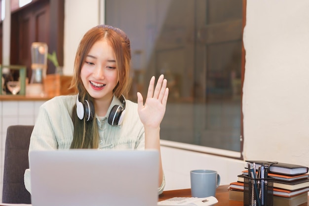 Concetto di lavoro a distanza Donna imprenditrice parla con un collega di saluto in videochiamata nello spazio di coworking