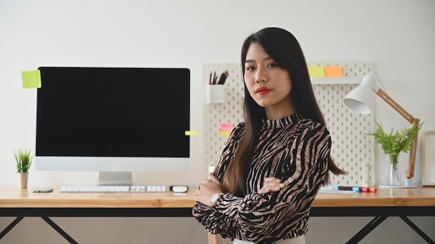 Concetto di lavoro della donna, artista creativo femminile che esamina macchina fotografica in ufficio alla moda.