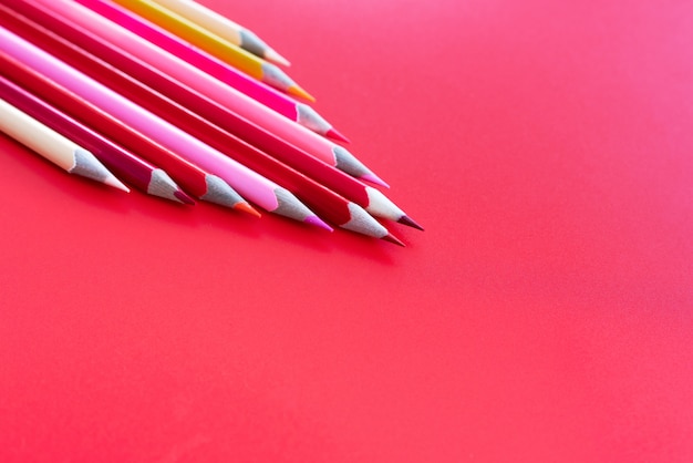Concetto di lavoro di squadra. gruppo di matita di colore su sfondo rosa