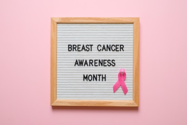 Concetto di layout flatlay di consapevolezza del cancro al seno su sfondo rosa