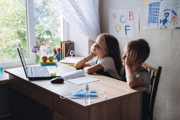 Concetto di lezioni a distanza di apprendimento a distanza di educazione domestica due scolari fratello e sorella in