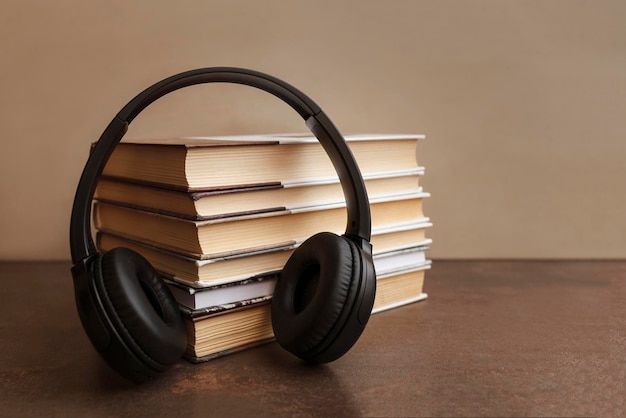 Concetto di libro audio Cuffie su libri su sfondo marrone Giornata mondiale del libro