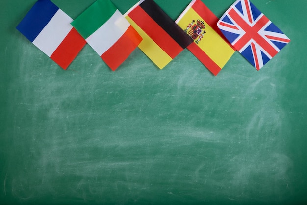 Concetto di lingue di apprendimento - bandiere di Spagna, Francia, Gran Bretagna, Russia e Italia sullo sfondo della lavagna