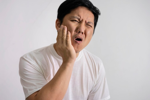 Concetto di mal di denti Inquadratura interna di un giovane maschio che sente dolore tenendo la guancia con la mano