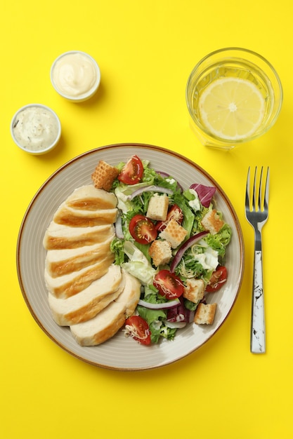 Concetto di mangiare gustoso con insalata Caesar su sfondo giallo