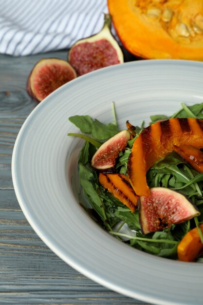 Concetto di mangiare gustoso con insalata di zucca su fondo di legno