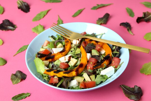 Concetto di mangiare gustoso con insalata di zucca su sfondo rosa