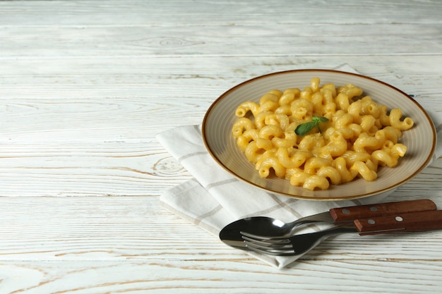 Concetto di mangiare gustoso con maccheroni al formaggio su fondo di legno