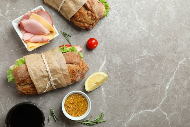 Concetto di mangiare gustoso con panini ciabatta su un tavolo strutturato grigio