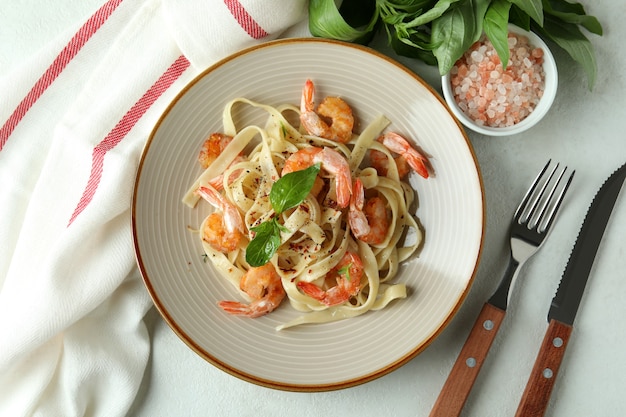 Concetto di mangiare gustoso con pasta di gamberetti su un tavolo strutturato bianco