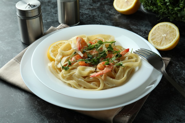 Concetto di mangiare gustoso con pasta di gamberetti sul tavolo affumicato nero