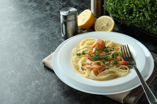 Concetto di mangiare gustoso con pasta di gamberetti sul tavolo affumicato nero