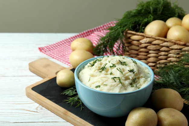 Concetto di mangiare gustoso con purè di patate su un tavolo di legno bianco