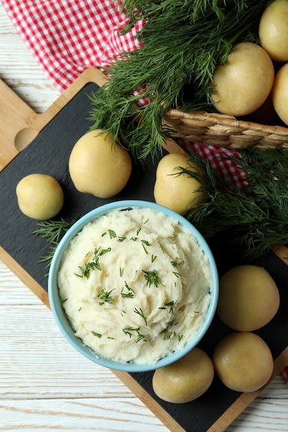 Concetto di mangiare gustoso con purè di patate su un tavolo di legno bianco