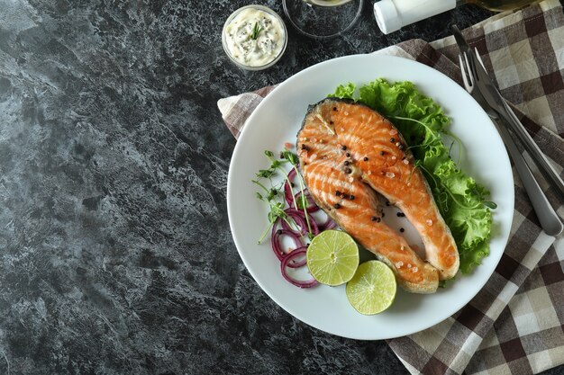 Concetto di mangiare gustoso con salmone alla griglia su un tavolo affumicato nero