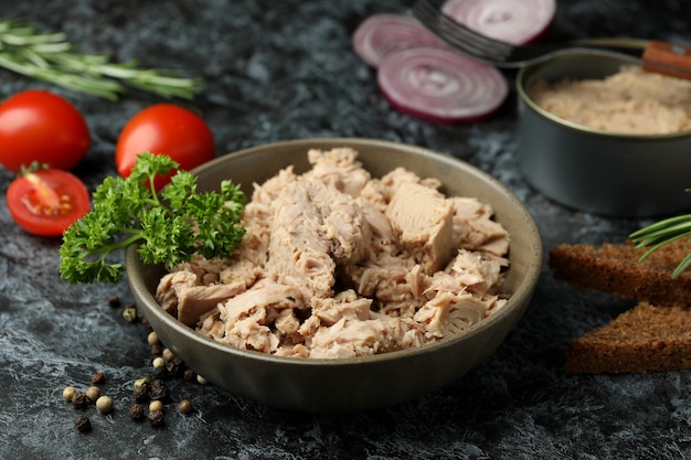 Concetto di mangiare gustoso con tonno in scatola su sfondo nero affumicato