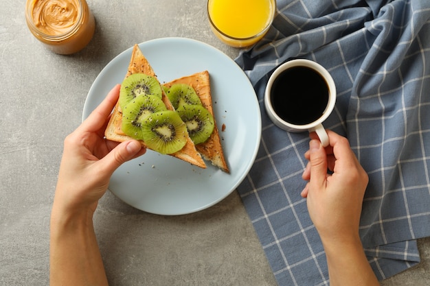 Concetto di mangiare pane tostato con kiwi