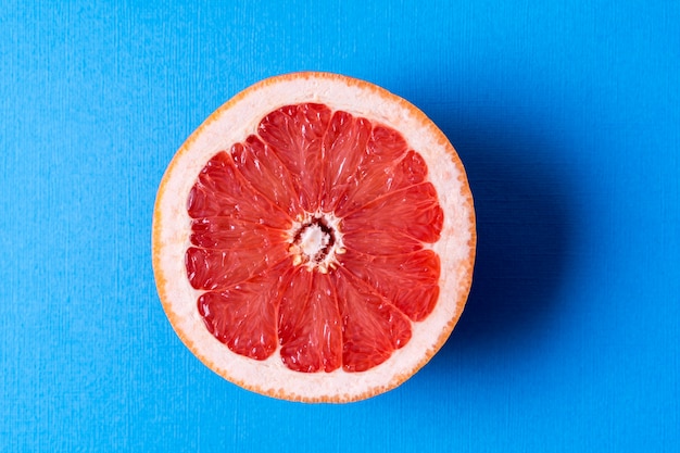 Concetto di mangiare sano. Frutta arancione rossa fresca cruda di vista piana di disposizione sopra fondo blu.