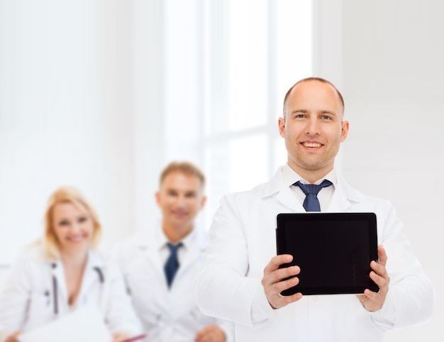 concetto di medicina, pubblicità e lavoro di squadra - medico maschio sorridente che mostra lo schermo del computer tablet pc su un gruppo di medici