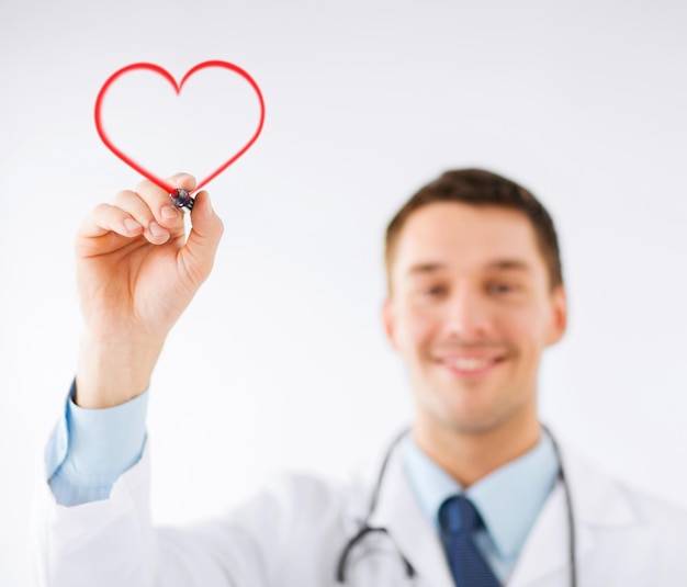 concetto di medicina, salute e ospedale - medico maschio che disegna il cuore nell'aria con un pennarello