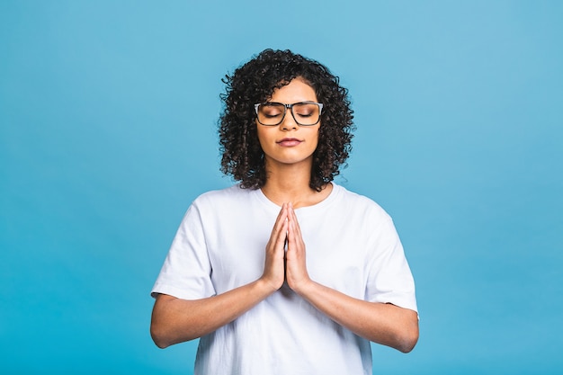 Concetto di meditazione. La bella giovane donna afroamericana si trova in posa meditativa, gode di un'atmosfera tranquilla