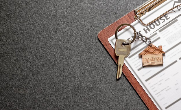 Concetto di mutuo, investimento, immobiliare e proprietà - Vista dall'alto delle chiavi di casa su appunti di legno.