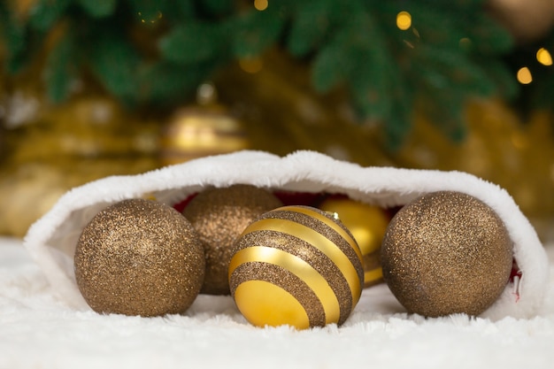 Concetto di natale. Bagattelle dorate in cappello di Babbo Natale