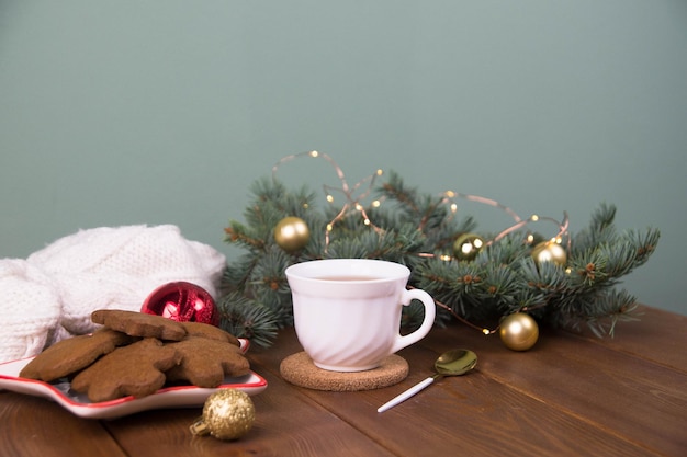 Concetto di Natale bicchiere di piatto da tè di biscotti rami di abete con giocattoli su legno
