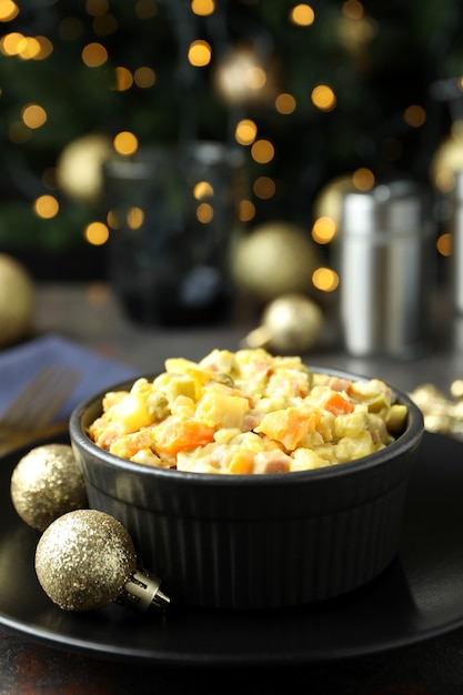 Concetto di Natale di cibo gustoso con insalata Olivier e bokeh