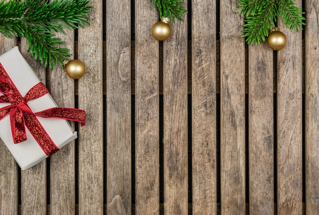 Concetto di Natale: regali con un ramoscello di abete rosso e decorazioni su un fondo di legno
