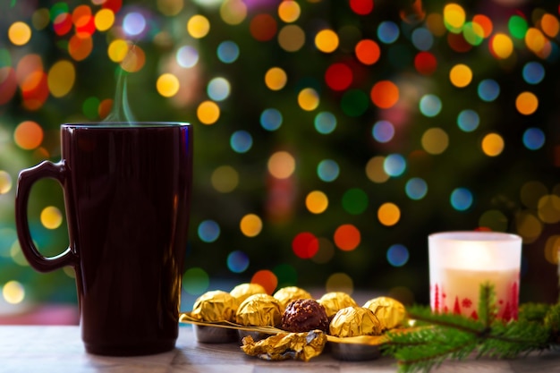 Concetto di Natale Una tazza di cioccolata calda sullo sfondo di un albero di Natale con luci