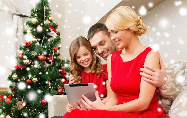 concetto di natale, vacanze, tecnologia e persone - famiglia sorridente con tablet pc a casa