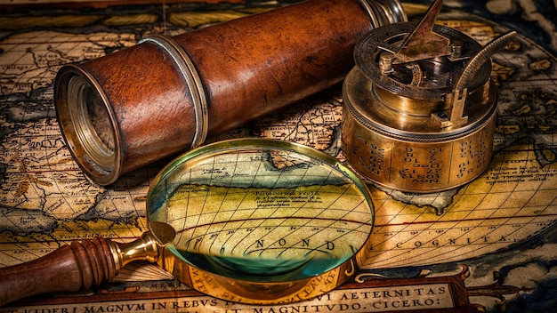 Concetto di navigazione geografia di viaggio vecchia bussola vintage con la corda del cannocchiale della meridiana sulla mappa del mondo