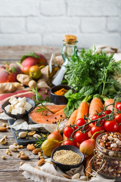 Concetto di nutrizione equilibrata per una dieta mediterranea flessibile e flessuosa. Assortimento di ingredienti alimentari sani per cucinare su un tavolo da cucina in legno.