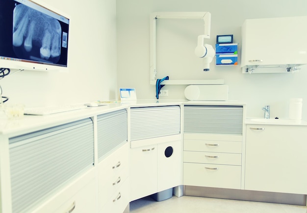 concetto di odontoiatria, medicina, attrezzatura medica e stomatologia - interno del nuovo studio dentistico moderno con sedia
