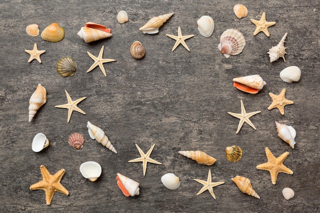 Concetto di ora legale Composizione piatta con bellissime stelle marine e conchiglie marine su tavolo colorato con vista dall'alto con spazio per la copia del testo