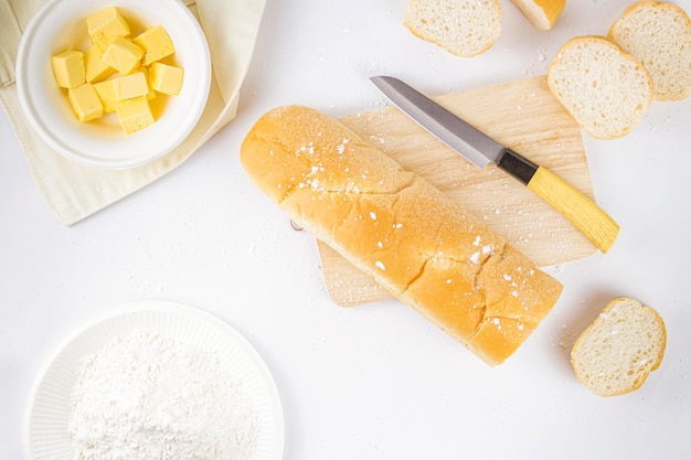 Concetto di pane una pagnotta di pane alcune fette di pane un coltello un tagliere di legno