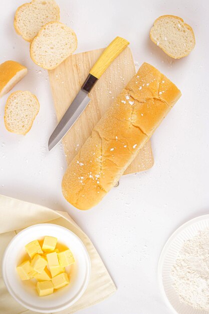 Concetto di pane una pagnotta qualche fetta di pane un coltello un tagliere di legno