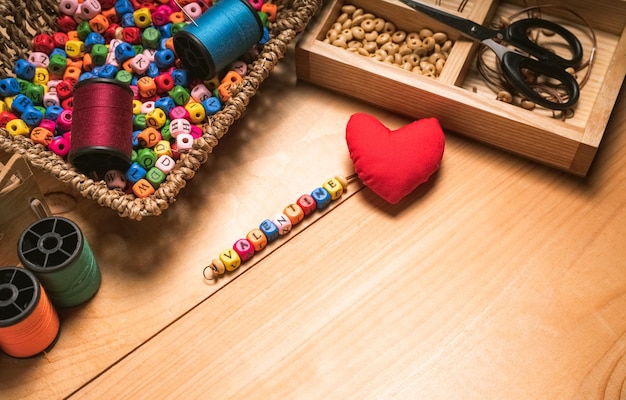 Concetto di parole Stringa di lettere in legno perline di parola AMORE Close up donna stringa di colore a mano in legno