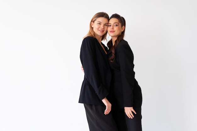 Concetto di partnership nel mondo degli affari Due Giovane imprenditrice vestita di nero abito formale in piedi studio isolato sfondo bianco
