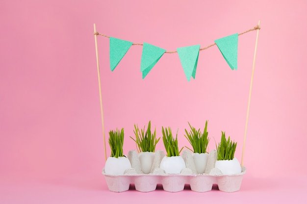 Concetto di Pasqua con le uova su uno sfondo rosa. Guscio d'uovo erba, primavera,