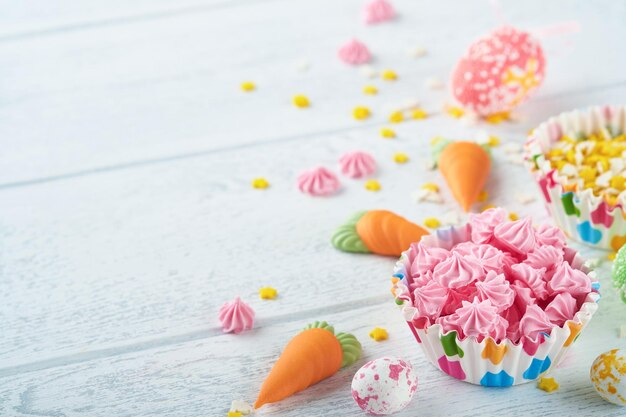 Concetto di Pasqua dolce Assortimento di vacanze per bambini dolci di Pasqua marshmallow coniglio cioccolatini uova di pasqua caramelle coniglietto snack su fondo di legno bianco Piatto laici idea di decorazione di Pasqua Mock up