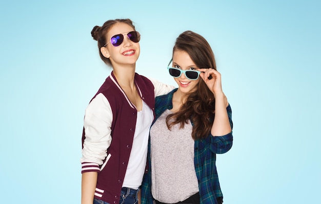 concetto di persone, amicizia, moda, estate e adolescenti - sorridenti belle ragazze adolescenti in occhiali da sole su sfondo blu