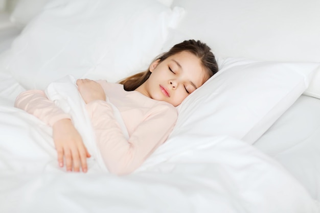 concetto di persone, bambini, riposo e comfort - ragazza che dorme a letto a casa