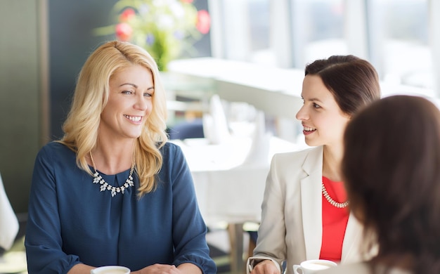 concetto di persone, comunicazione e stile di vita - donne felici che bevono caffè e parlano al ristorante