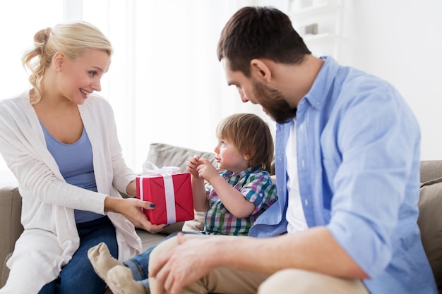 concetto di persone e vacanze - famiglia felice con regalo di compleanno a casa