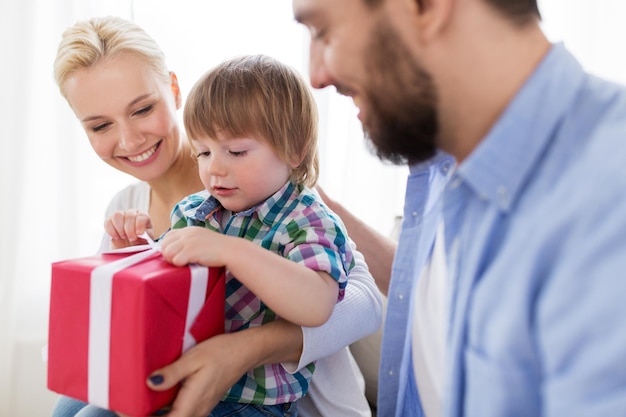 concetto di persone e vacanze - famiglia felice con regalo di compleanno a casa