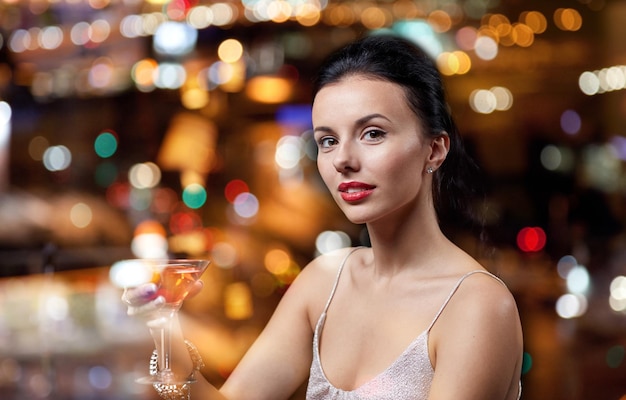 concetto di persone, feste, vita notturna, bevande e vacanze - donna affascinante con cocktail al night club o al bar